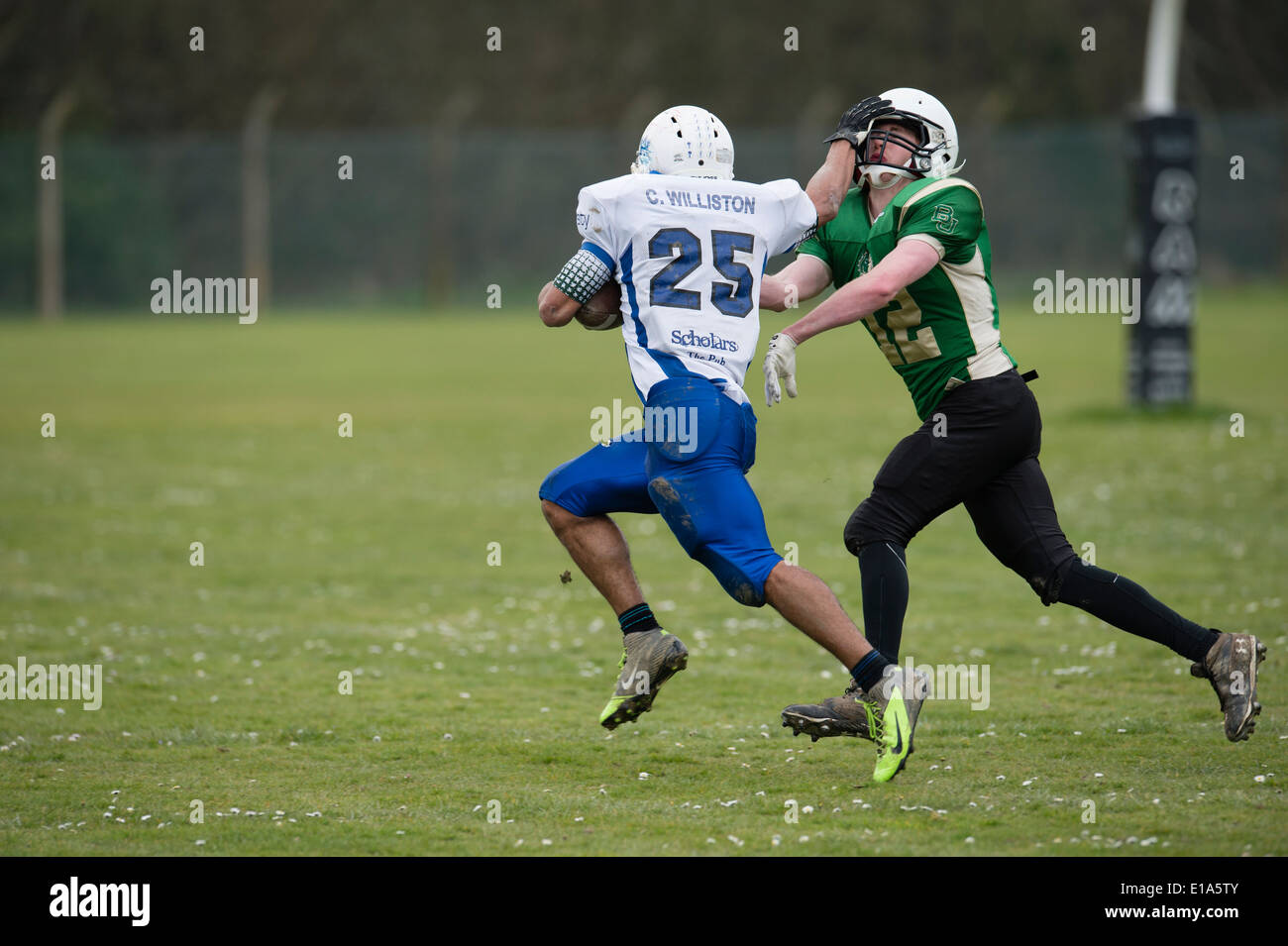 Sport Educazione NEL REGNO UNITO: Tarannau, Aberystwyth University american football team (in bianco) giocando una partita del campionato Galles REGNO UNITO - un corridore con la palla spinge via un potenziale tackler Foto Stock