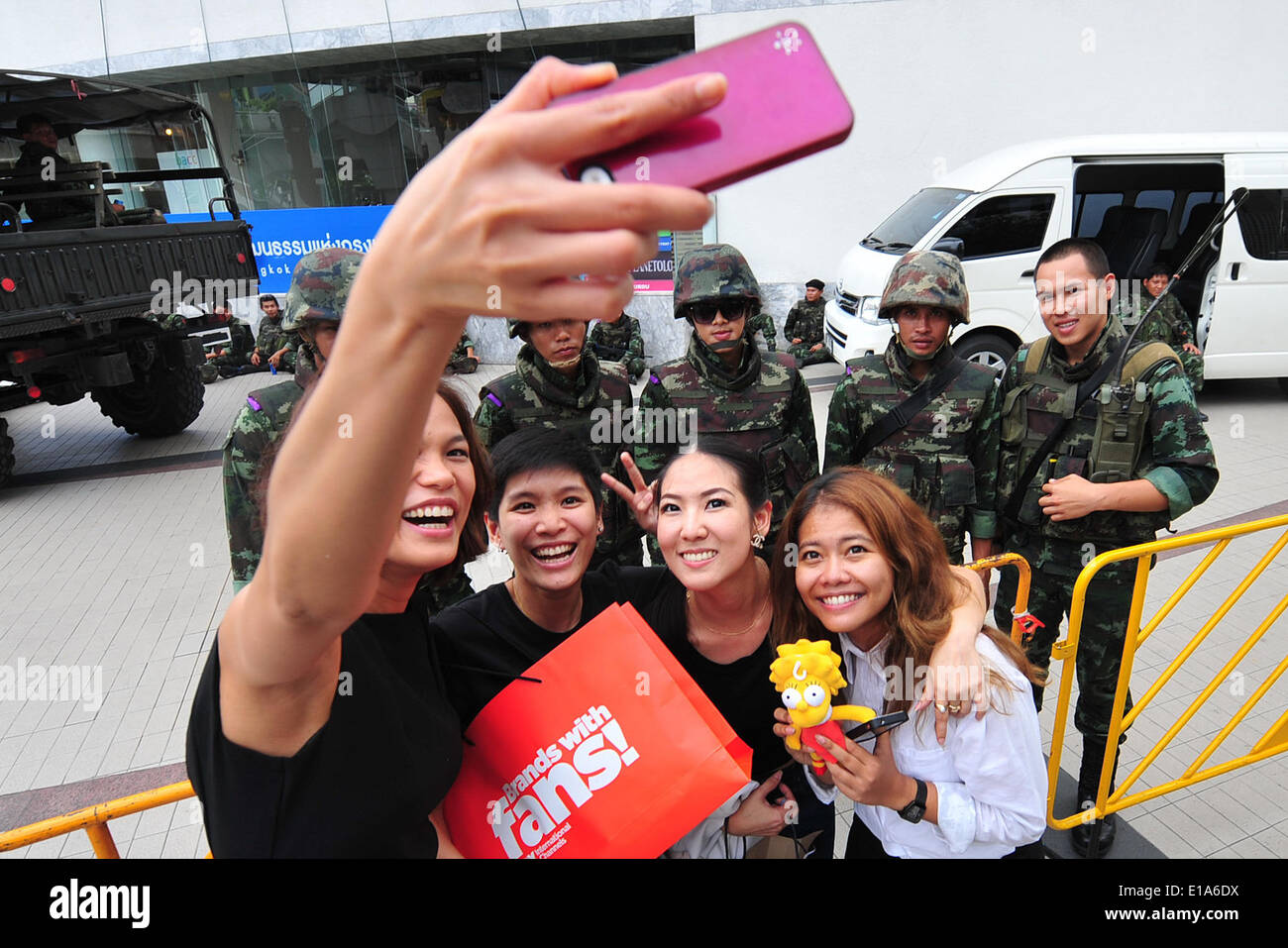 (140528) -- Bangkok, 28 maggio 2014 (Xinhua) -- la gente a prendere foto con soldati tailandesi di al di fuori dell'Arte Cultura Centre a Bangkok, Thailandia, 28 maggio 2014. Thailandia del colpo di stato è stato negativo di credito per la Thailandia del settore turistico per motivi compresi avvisi di viaggio contro la Tailandia, il coprifuoco a livello nazionale come pure accorciato le ore di funzionamento di magazzini e mezzi di trasporto pubblico. (Xinhua/Rachen Sageamsak) (zjy) Foto Stock