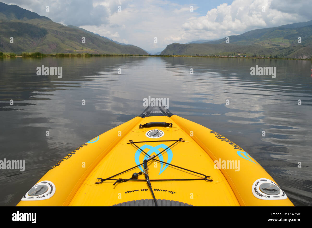 SUP Stand Up Paddleboarding sulle sponde di un lago vicino a Cusco, Perù con lo sfondo delle Ande Foto Stock