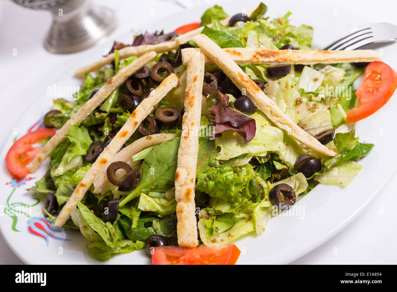 Insalata mediterranea con le olive a fette, lattuga, spinaci pomodori e olio di oliva stagionatura e disposti con le fette di pita Foto Stock