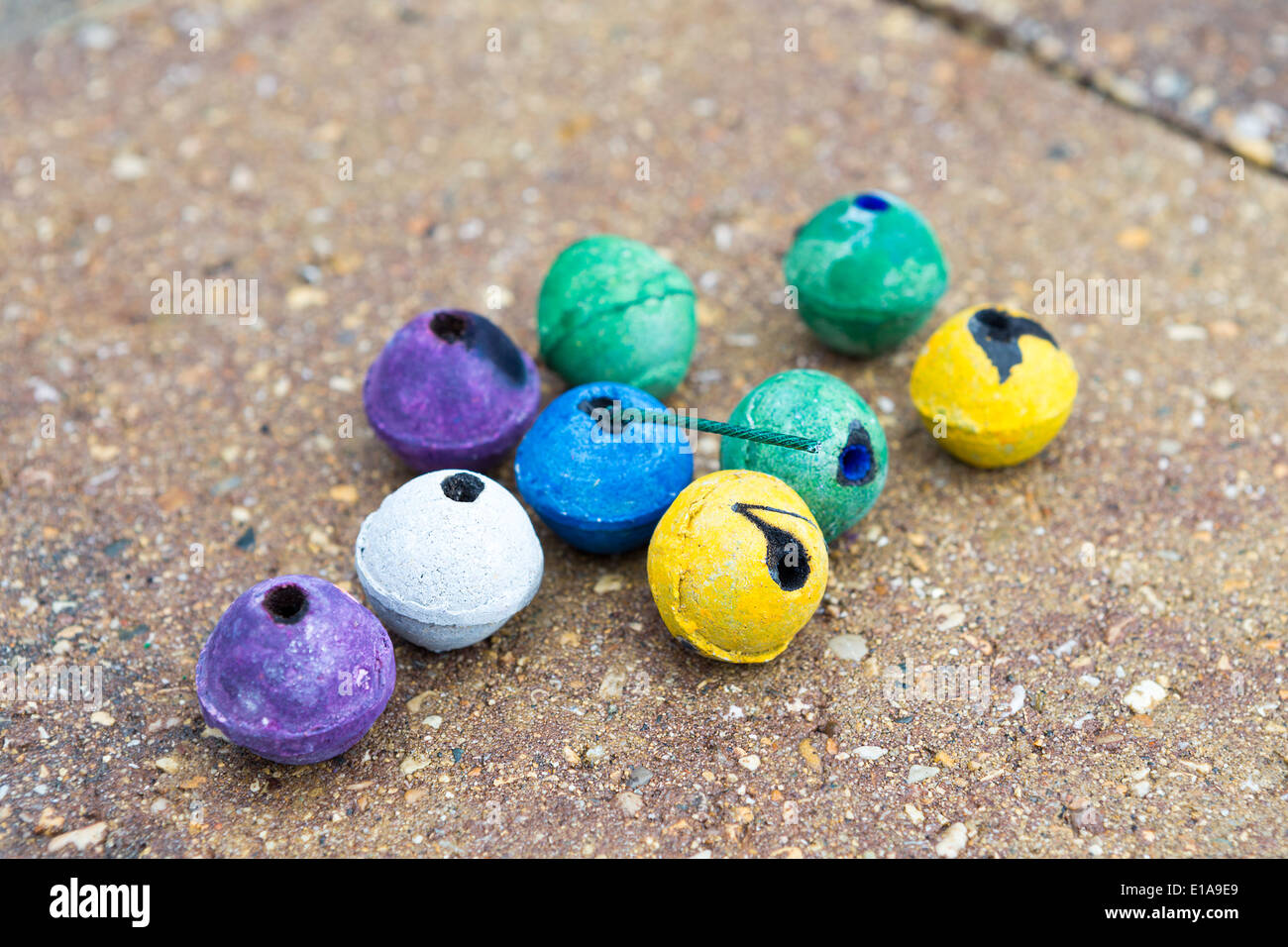 Rotondo colorato fumo bombe naturalmente sul lastricatore street alcune di esse utilizzate alcuni di loro non. Essi hanno viola, verde, giallo, WH Foto Stock