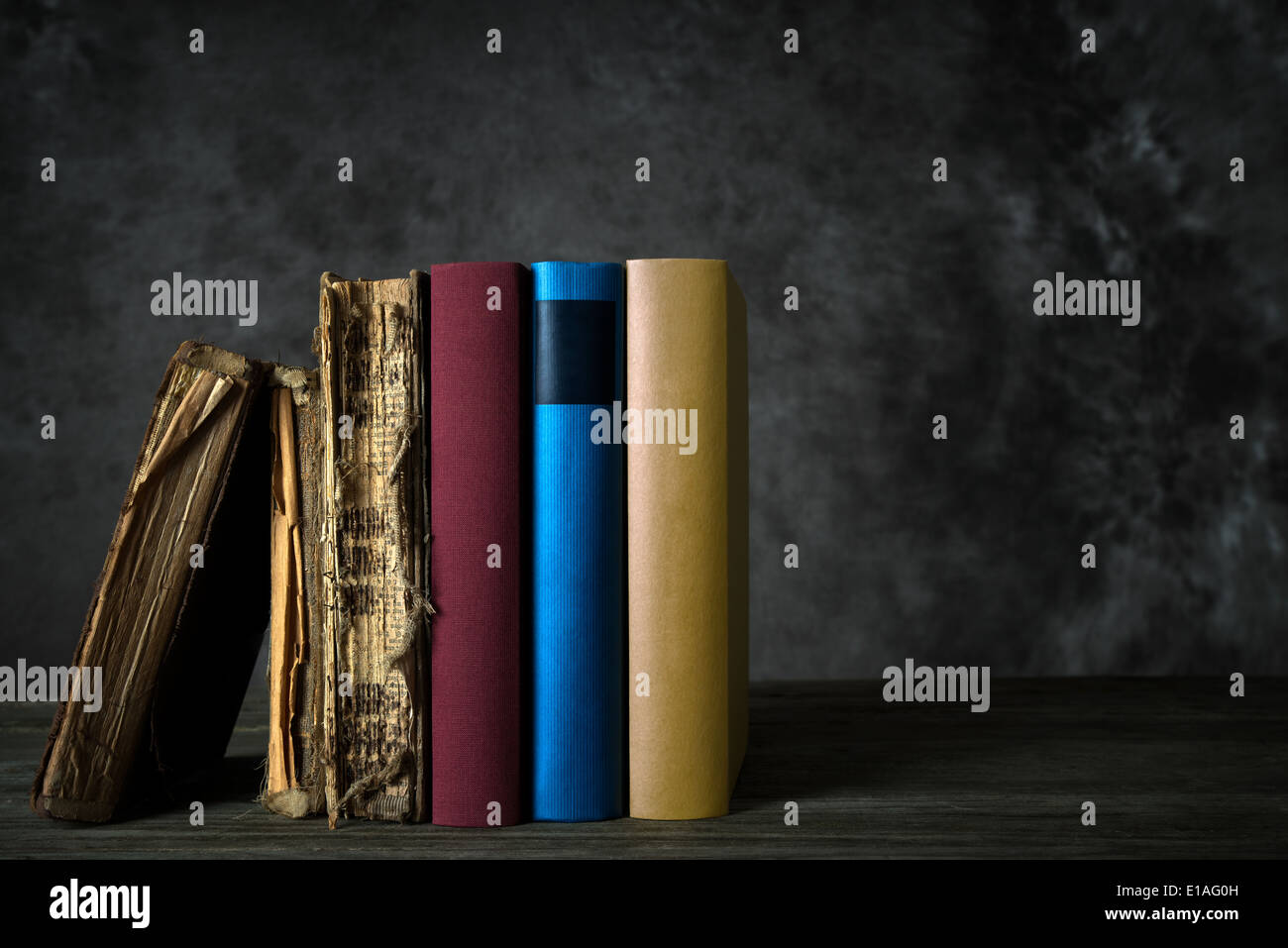 Scaffale con vecchi mobili di antiquariato e ingiallito libri e nuovi libri colorati Foto Stock