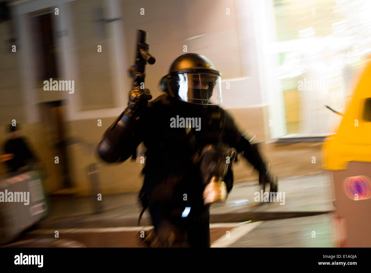 Barcellona, Spagna, 28 maggio, 2014. Un poliziotto antiriot corre con un fucile attraverso le strade di Barcellona. Seconda notte di proteste e di scontri nel quartiere Sants di Barcellona dopo lo sfratto di uno squat dalla polizia. Credito: Jordi Boixareu/Alamy Live News Foto Stock