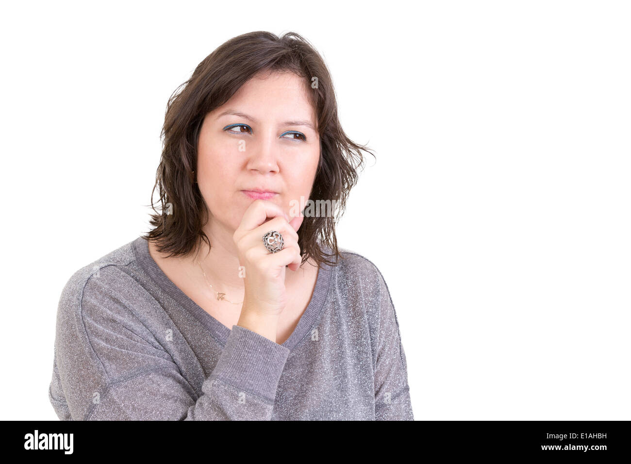 Donna con un calcolo pensieroso guarda seduto con la sua mano a suo mento come lei di piani e progetti per il futuro, isolata su whi Foto Stock