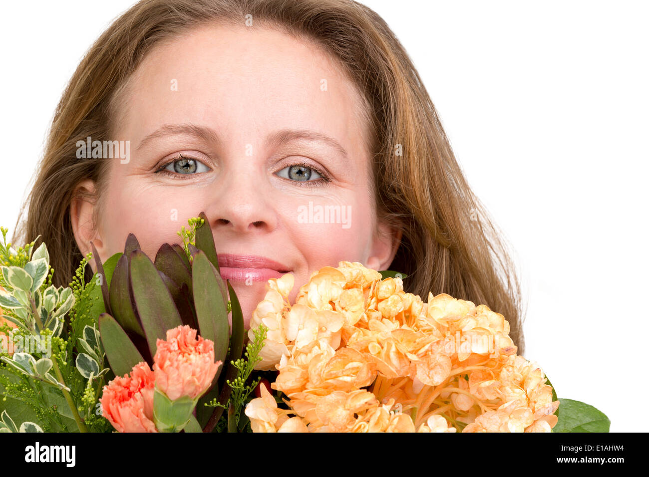 Felice donna sorridente dietro il mazzo di fiori che esprime i suoi sentimenti realmente, isolato su bianco Foto Stock