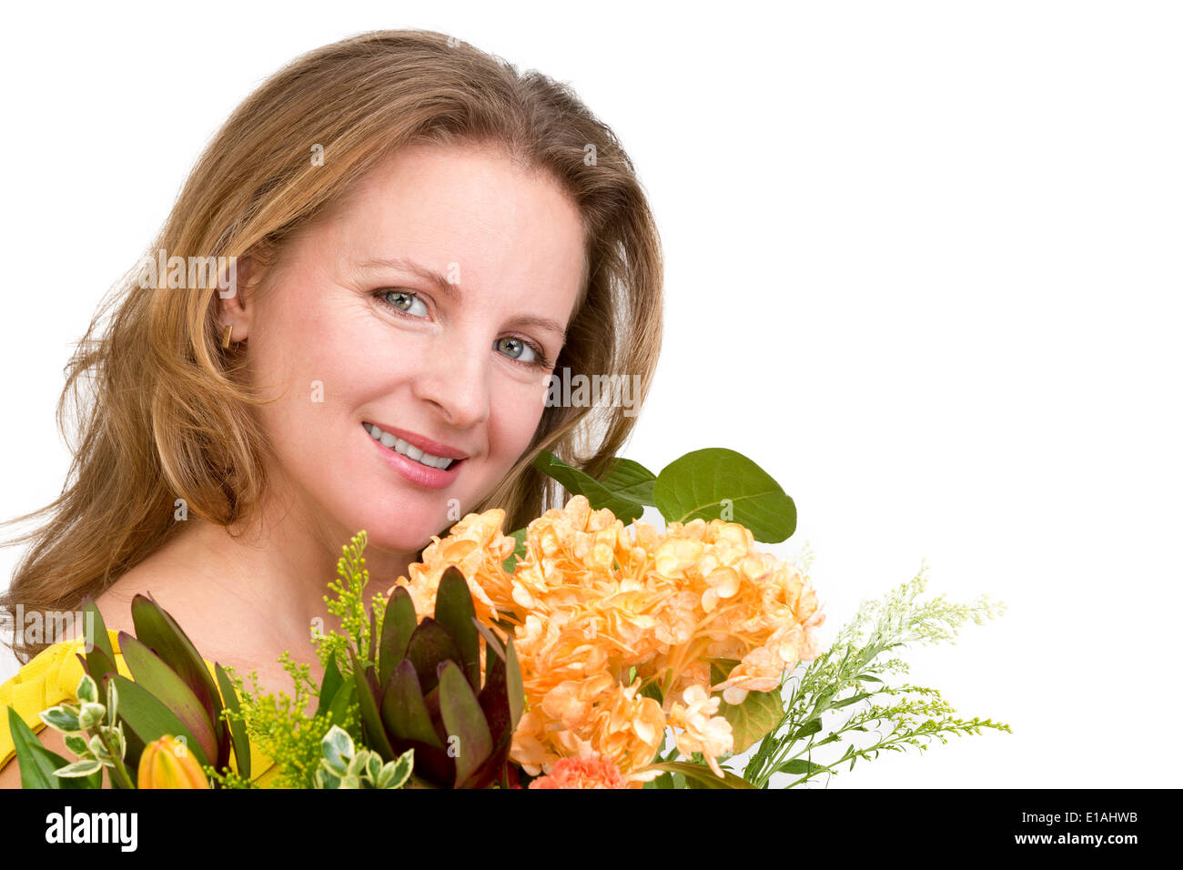 Felice donna sorridente dietro il mazzo di fiori che esprime i suoi sentimenti positivi genuinamente Foto Stock