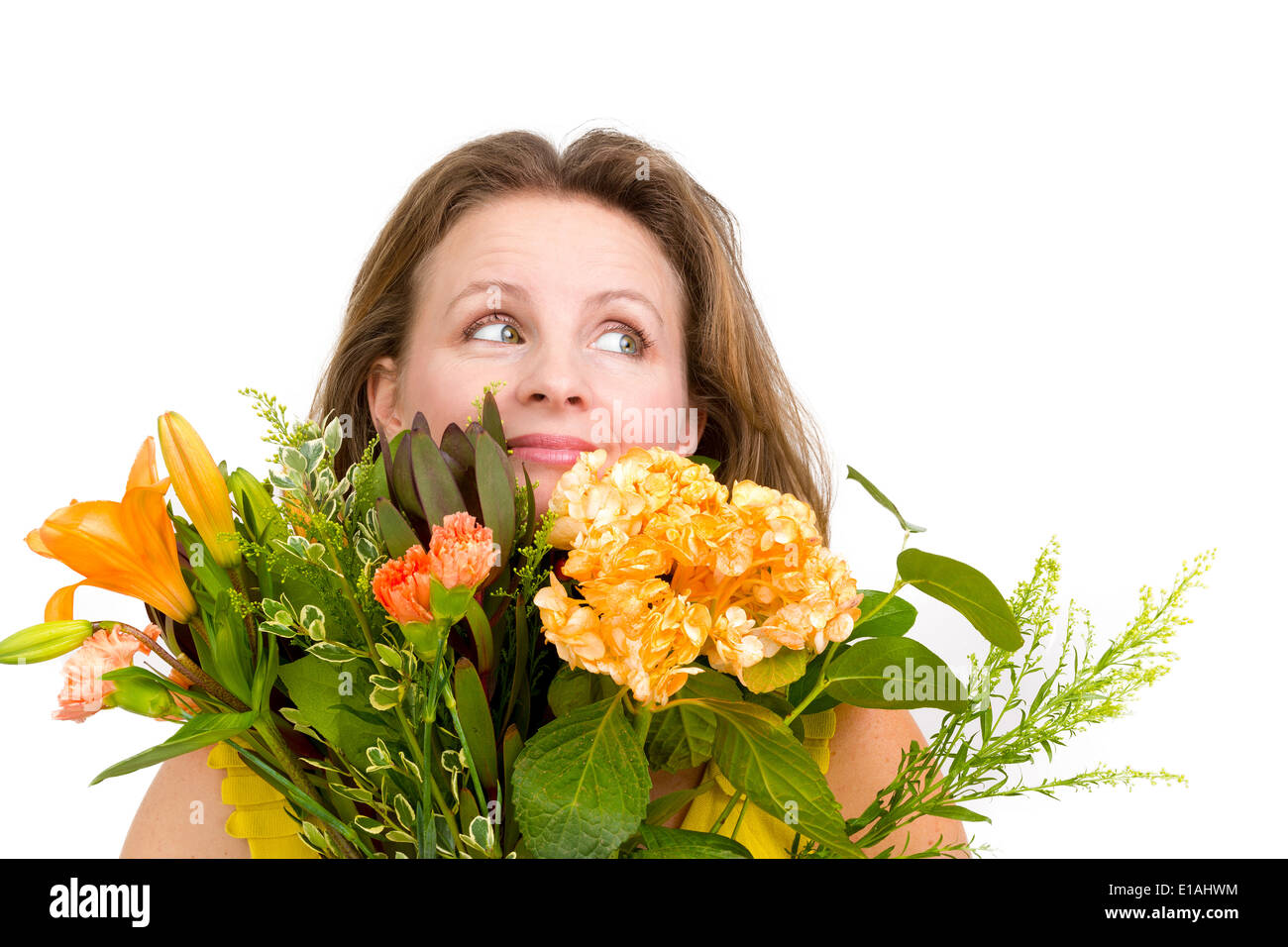 Felice donna che guarda verso l'alto dietro il mazzo di fiori che esprime i suoi sentimenti positivi genuinamente Foto Stock