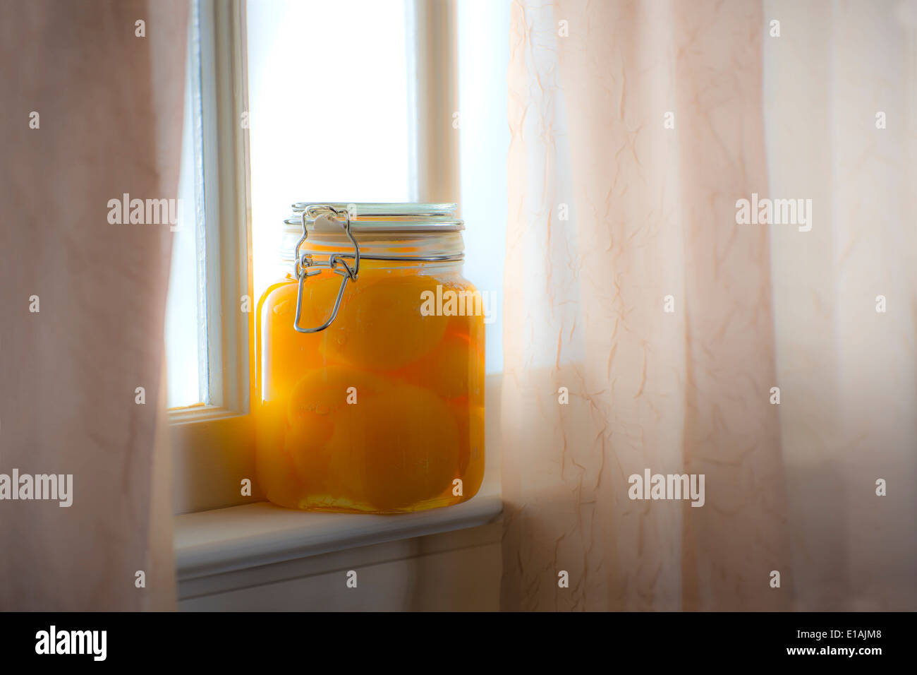 Vasetto di pesche dalla finestra soleggiata con tende giorno di estate Foto Stock