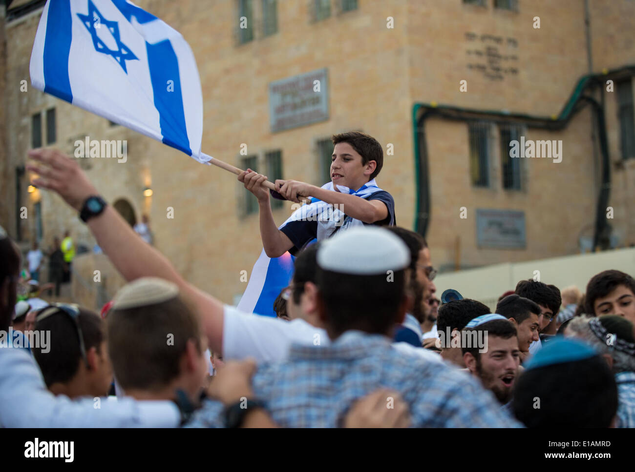 Gerusalemme, Israele. 28 Maggio, 2014. Un ragazzo ebreo onde un israeliano bandiera nazionale sulla piazza di fronte al Muro occidentale nella città vecchia di Gerusalemme, il 28 maggio 2014, durante una parata ebraico la marcatura del XLVII anniversario della Giornata di Gerusalemme. Più di ventimila persone il mercoledì hanno marciato per le strade di Gerusalemme per celebrare il 47esimo anniversario di Gerusalemme il giorno, un occasione per contrassegnare il '" di riunificazione della città dopo che Israele ha preso il controllo di arabo parte orientale durante il 1967 Medio Oriente la guerra. Credito: Xinhua/Alamy Live News Foto Stock