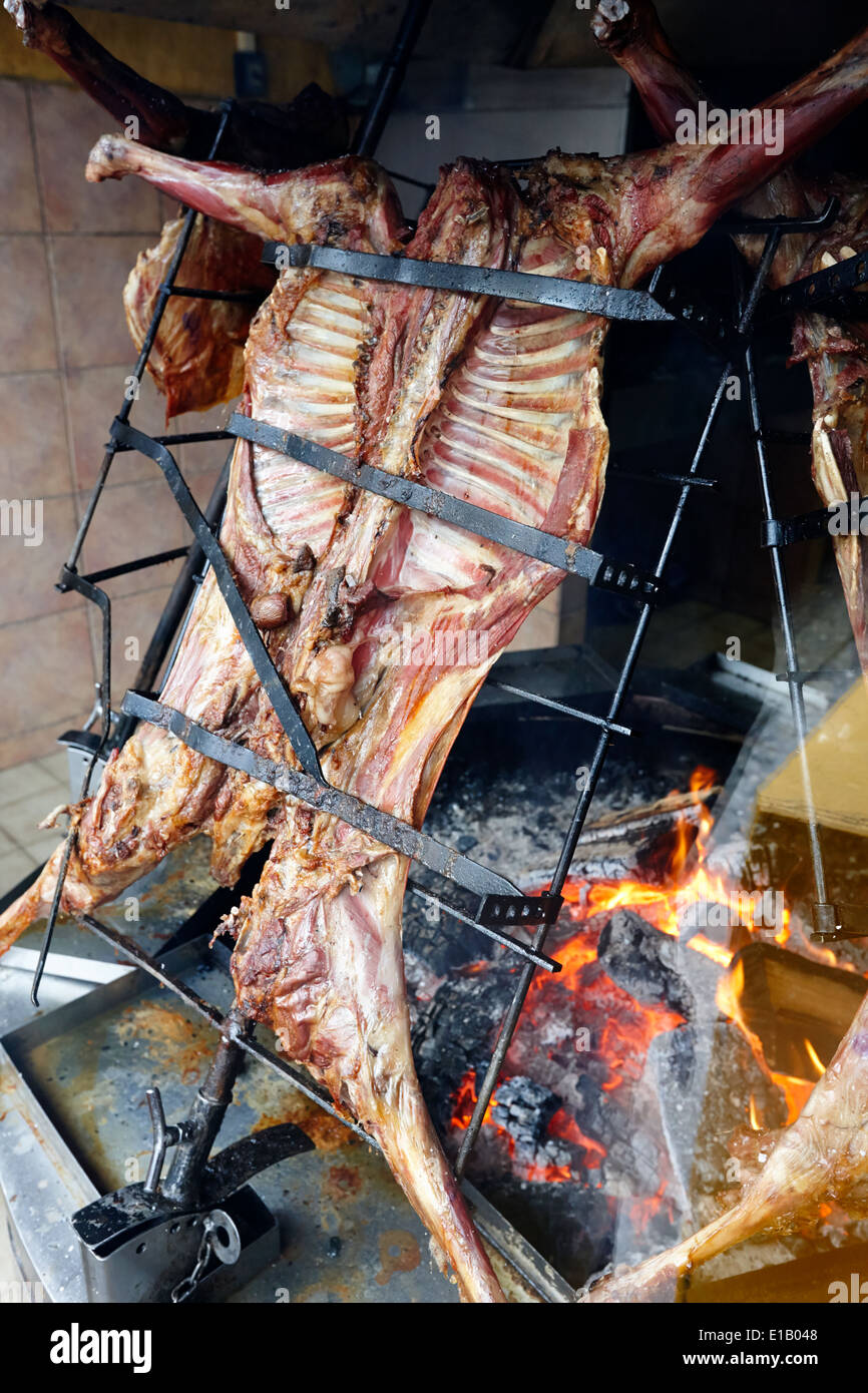 L'argentino asado agnello intero, la tostatura su bruciare un fuoco aperto nella finestra ristorante Ushuaia Argentina Foto Stock