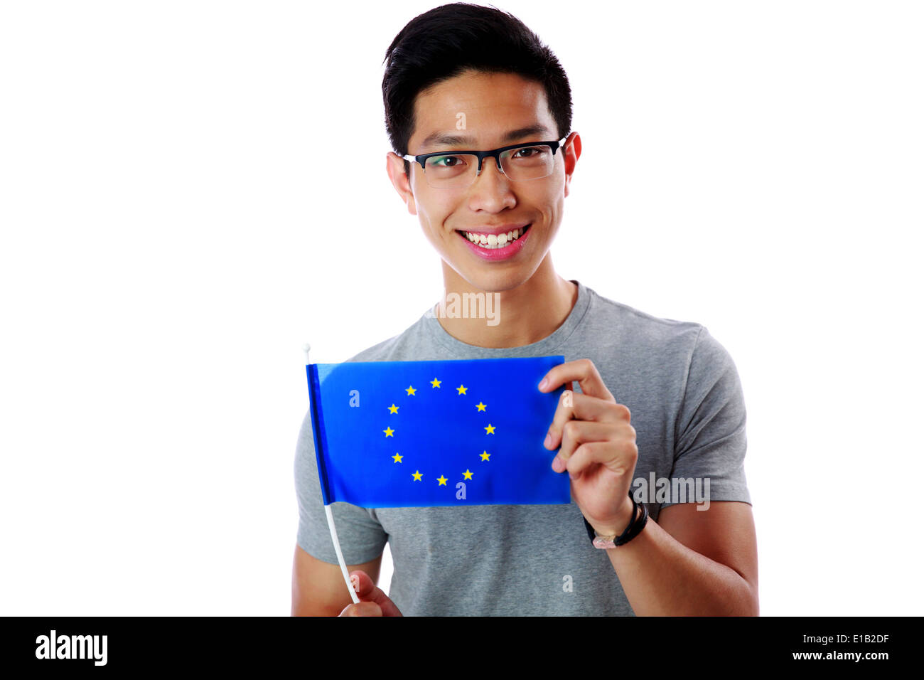 Felice giovane uomo asiatico holding bandiera dell'Unione europea su sfondo bianco Foto Stock