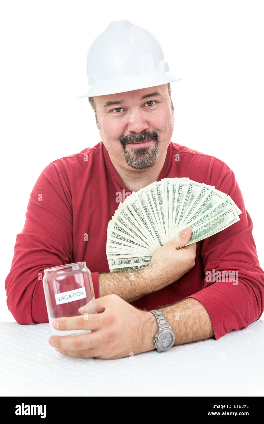 Lavoratore edile con un hard-hat holding vacanze denaro Foto Stock