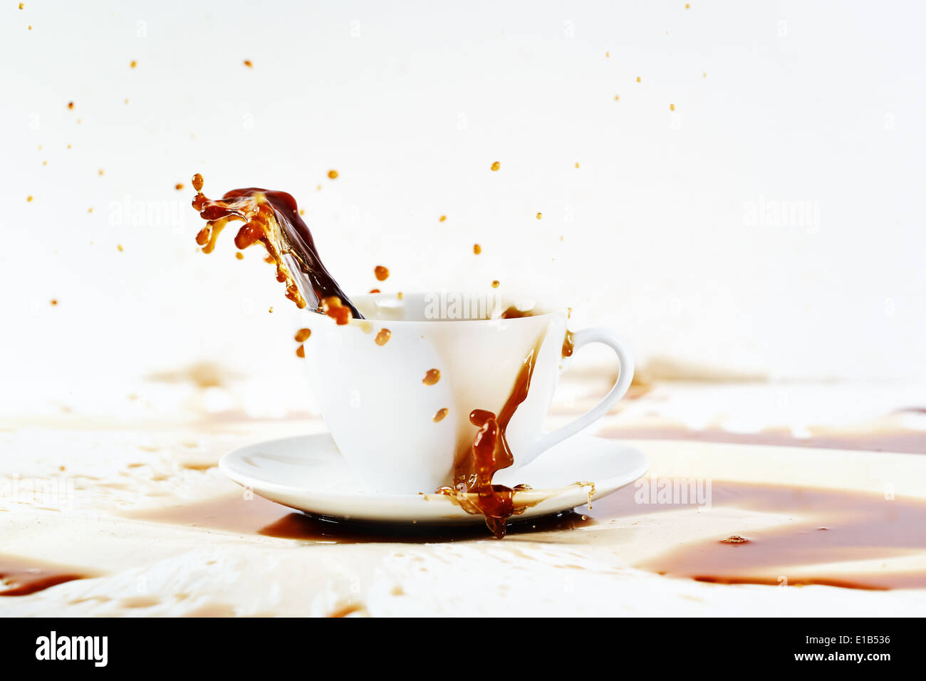 Tazza di caffè la fuoriuscita di creare splendidi splash con macchie sul bianco. Coffee break, colazione concetto. Foto Stock