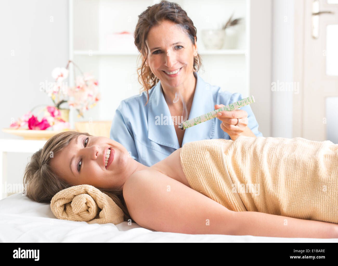 Medicina alternativa terapista facendo moxa trattamento su il suo cliente Foto Stock