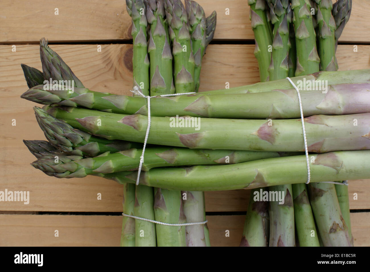 Asparago Verde giacente su di un tavolo di legno Foto Stock