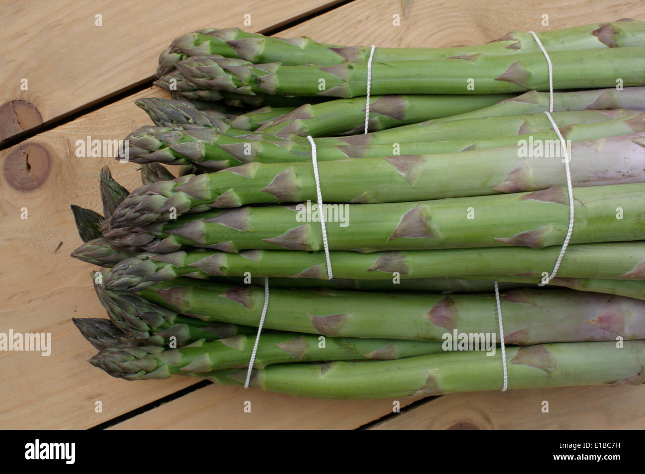 Asparago Verde giacente su di un tavolo di legno Foto Stock
