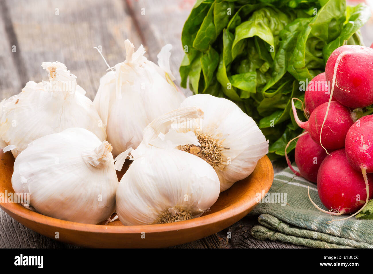 Fresco e salutare tutta bulbi di aglio,. un mazzetto di croccante radicchio rosso e verde lattuga pronto a fare una deliziosa insalata come un acc Foto Stock