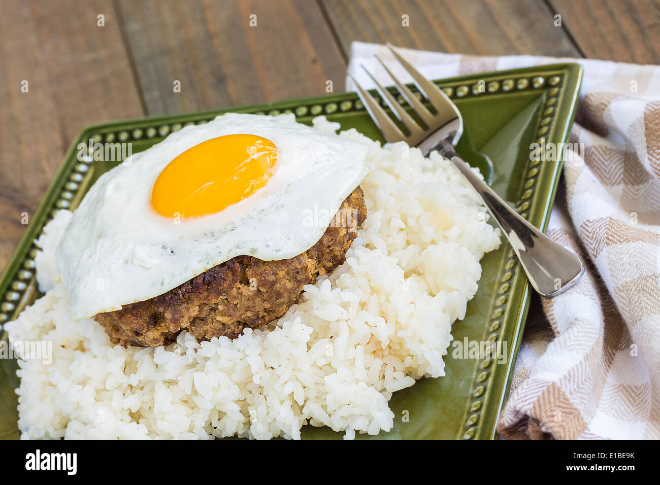 Loco Moco, hawaiano tradizionale piatto di teriyaki aromatizzati polpetta di carne macinata e un uovo fritto su un letto di riso Foto Stock