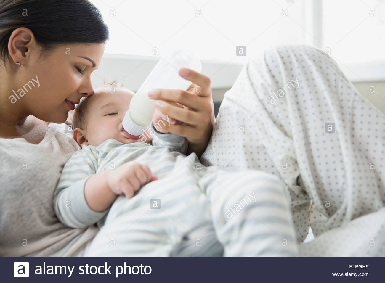 Serena la madre del bambino di alimentazione sul letto Foto Stock
