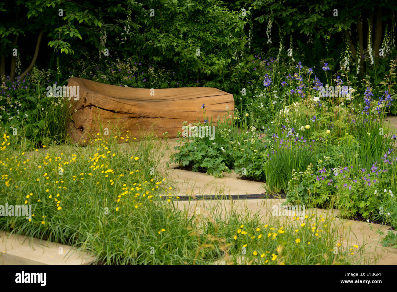 Una panca in legno e pietra percorso nel giardino Homebase al Chelsea Flower Show 2014, London, Regno Unito Foto Stock
