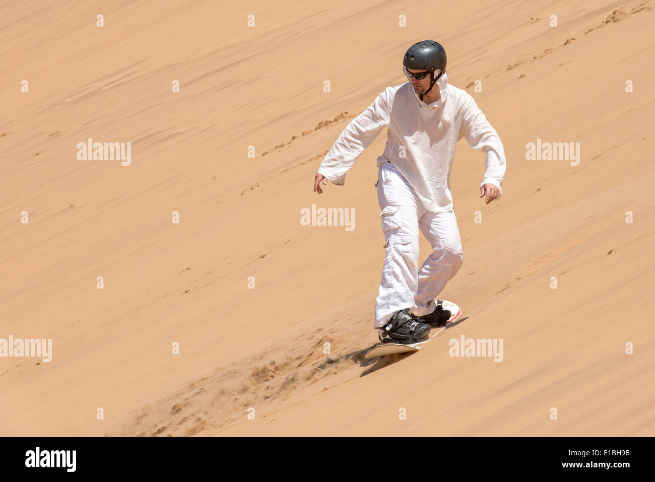 L'uomo godendo sandboarding in Namibia Foto Stock