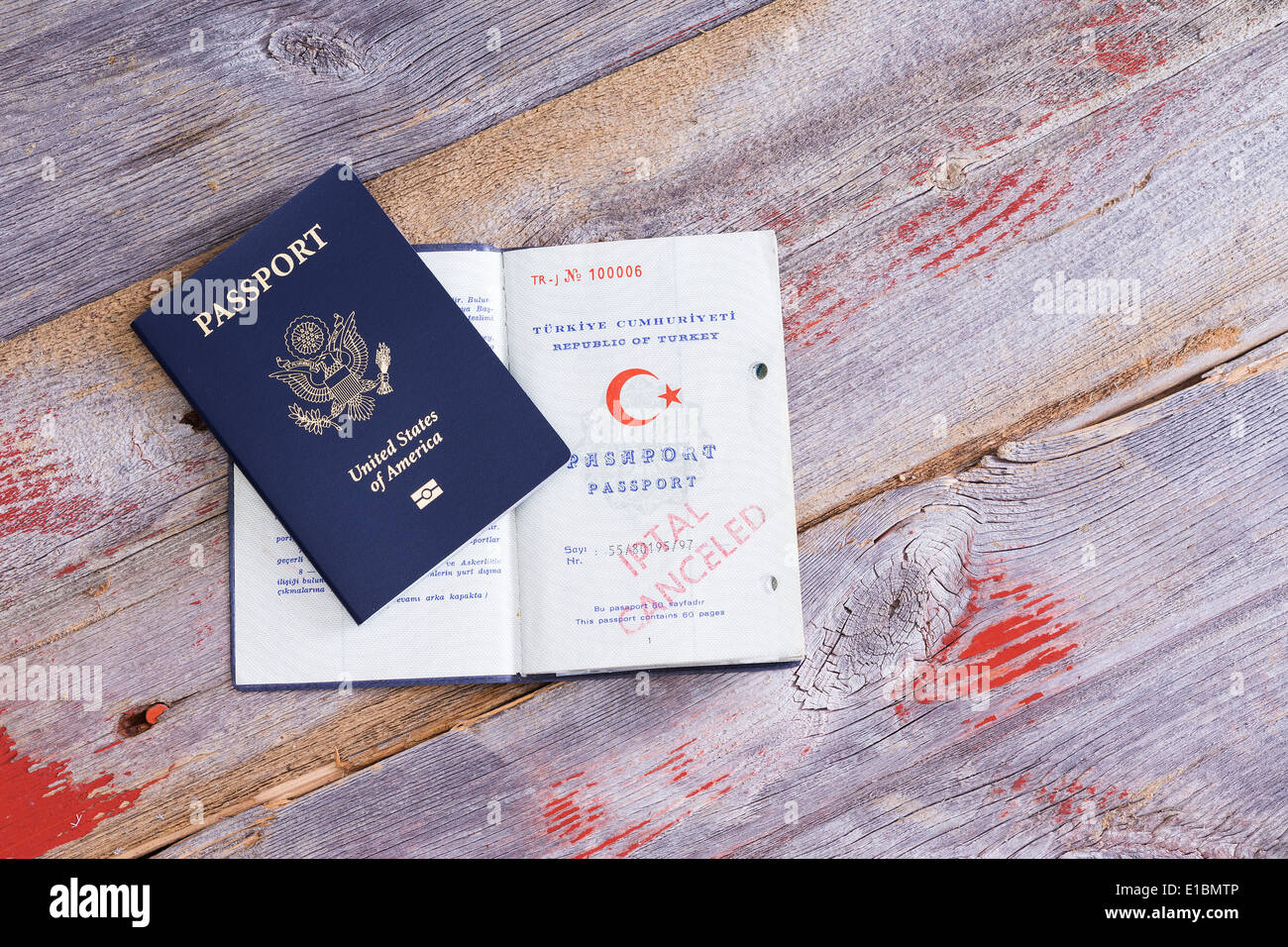 Un americano ed un passaporto turco giacente su un vecchio tavolo di legno con il passaporto turco aperti per visualizzare una mano annullato timbro Foto Stock