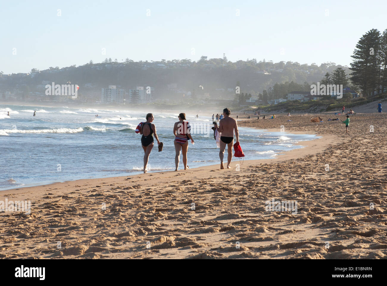 Tre persone a piedi lungo il litorale a North Narrabeen beach, Sydney. Foto Stock