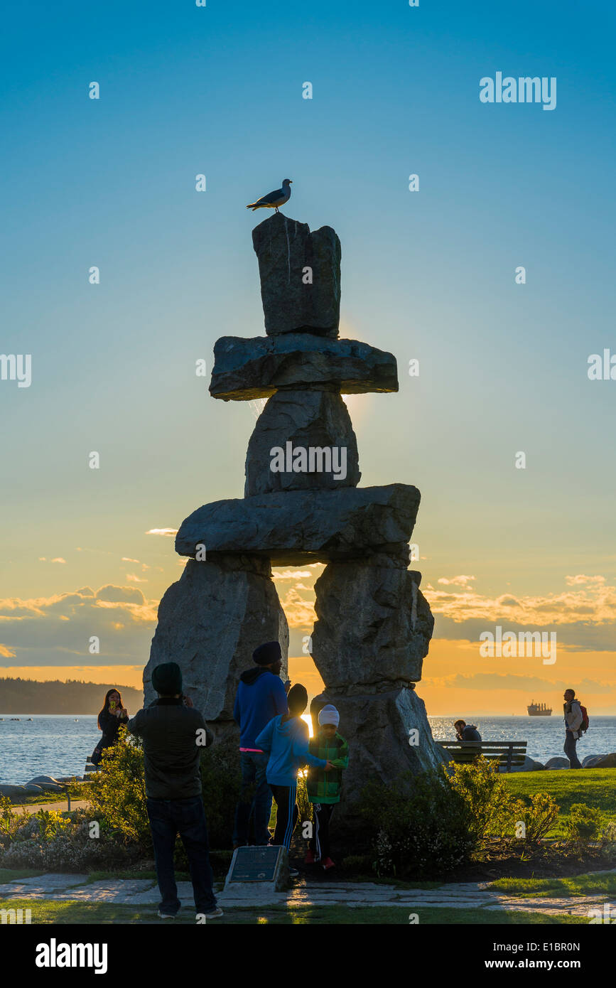 I turisti scattare foto al Inukshuk al tramonto, English Bay, Vancouver, British Columbia, Canada Foto Stock