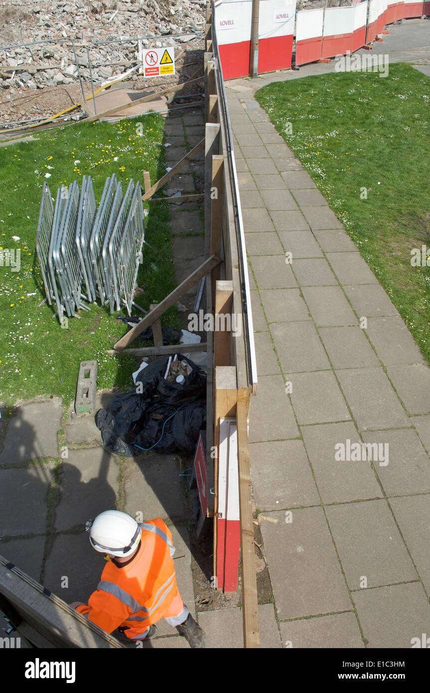 Lavoratore di demolizione in elmetto e GIUBBETTO ALTA VISIBILITA sito di inserimento Foto Stock
