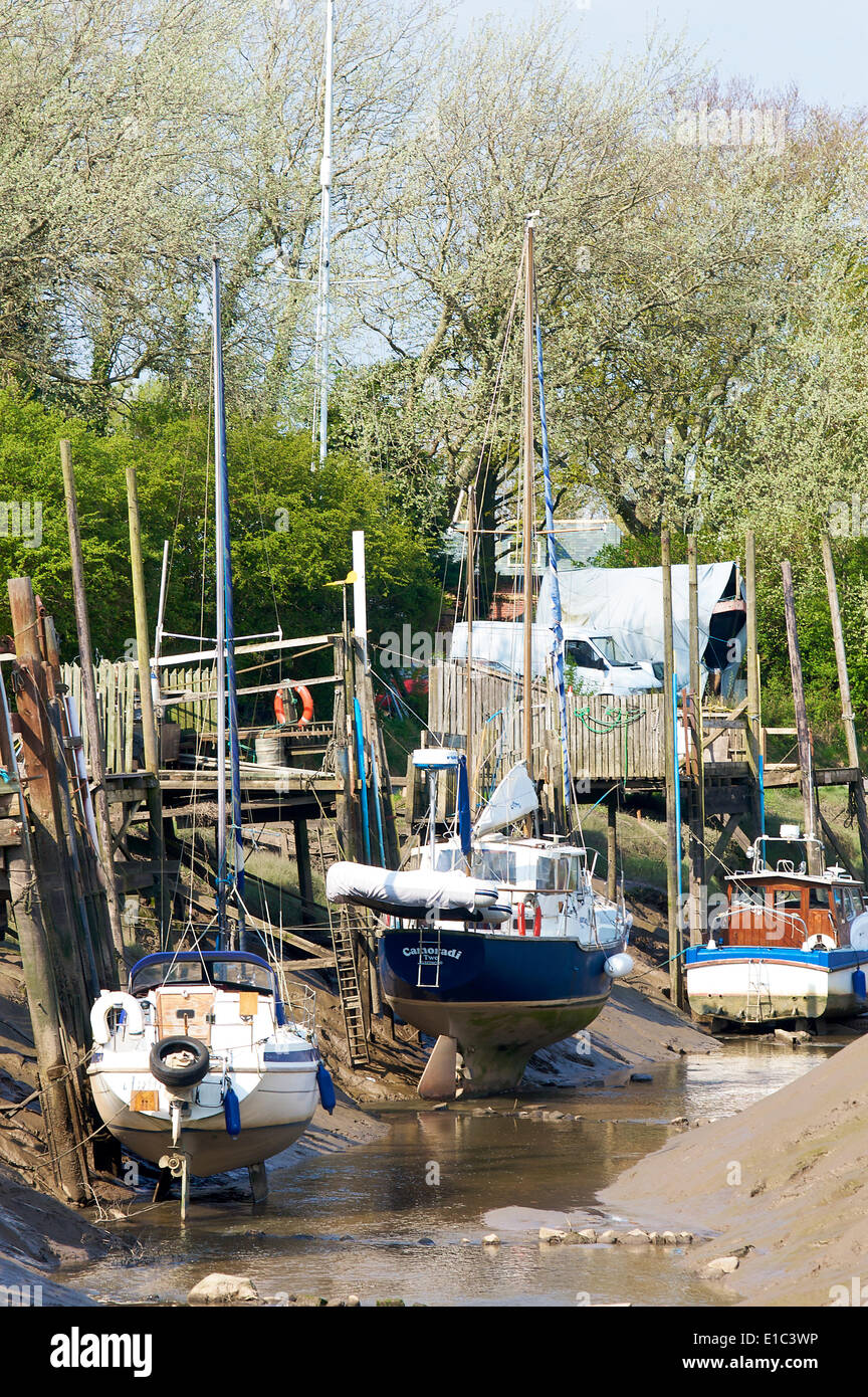 Piccole barche ormeggiate sul torrente Skippool durante la bassa marea Foto Stock