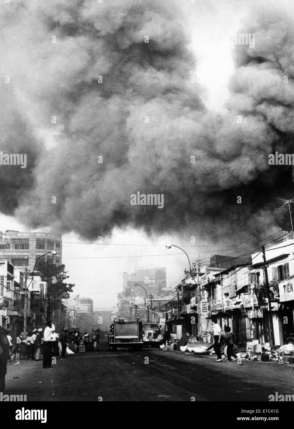 Guerra del Vietnam, fumo nero sopra la città capitale, camion fuoco rush per scene di incendi impostato durante gli attacchi dai Viet Cong Foto Stock