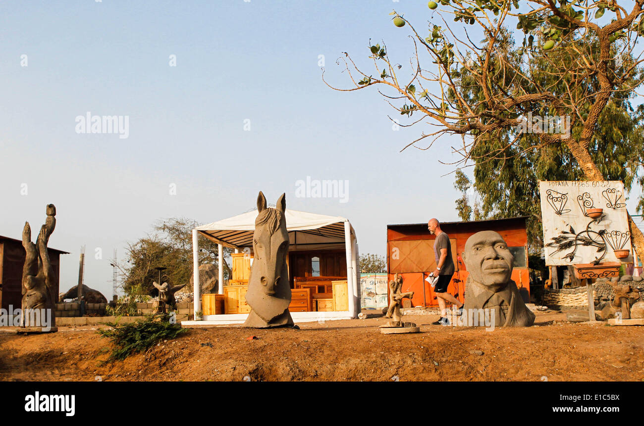 Dakar, Senegal. Il 30 maggio 2014. Un pareggiatore costeggia un outdoor artwork workshop a Dakar, capitale del Senegal, 30 maggio 2014. L'undicesima edizione dell'arte contemporanea africana biennale, Dak nell'arte, si terrà in Senegal dal 9 maggio al 8 giugno. Dakar si trova sulla penisola di Cap-Vert sulla costa atlantica. La sua posizione, sul bordo occidentale dell'Africa, è un vantaggio per l'integrazione di arte contemporanea africana nel mercato internazionale dell'arte. © Li Jing/Xinhua/Alamy Live News Foto Stock