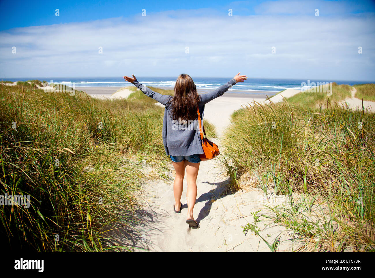 Una giovane donna arriva alla spiaggia Foto Stock