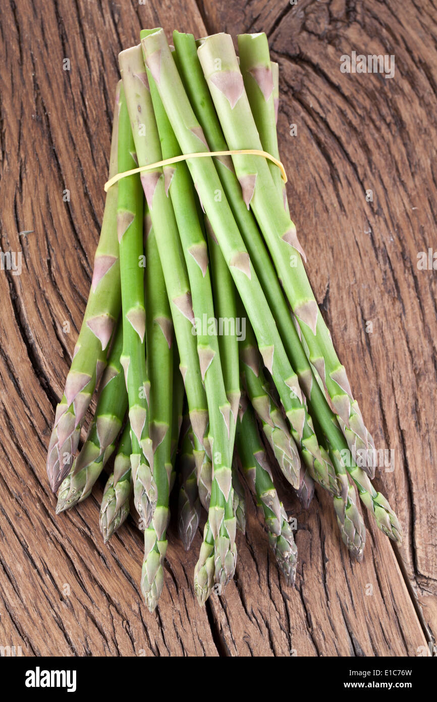 Mazzetto di asparagi su un tavolo di legno. Foto Stock