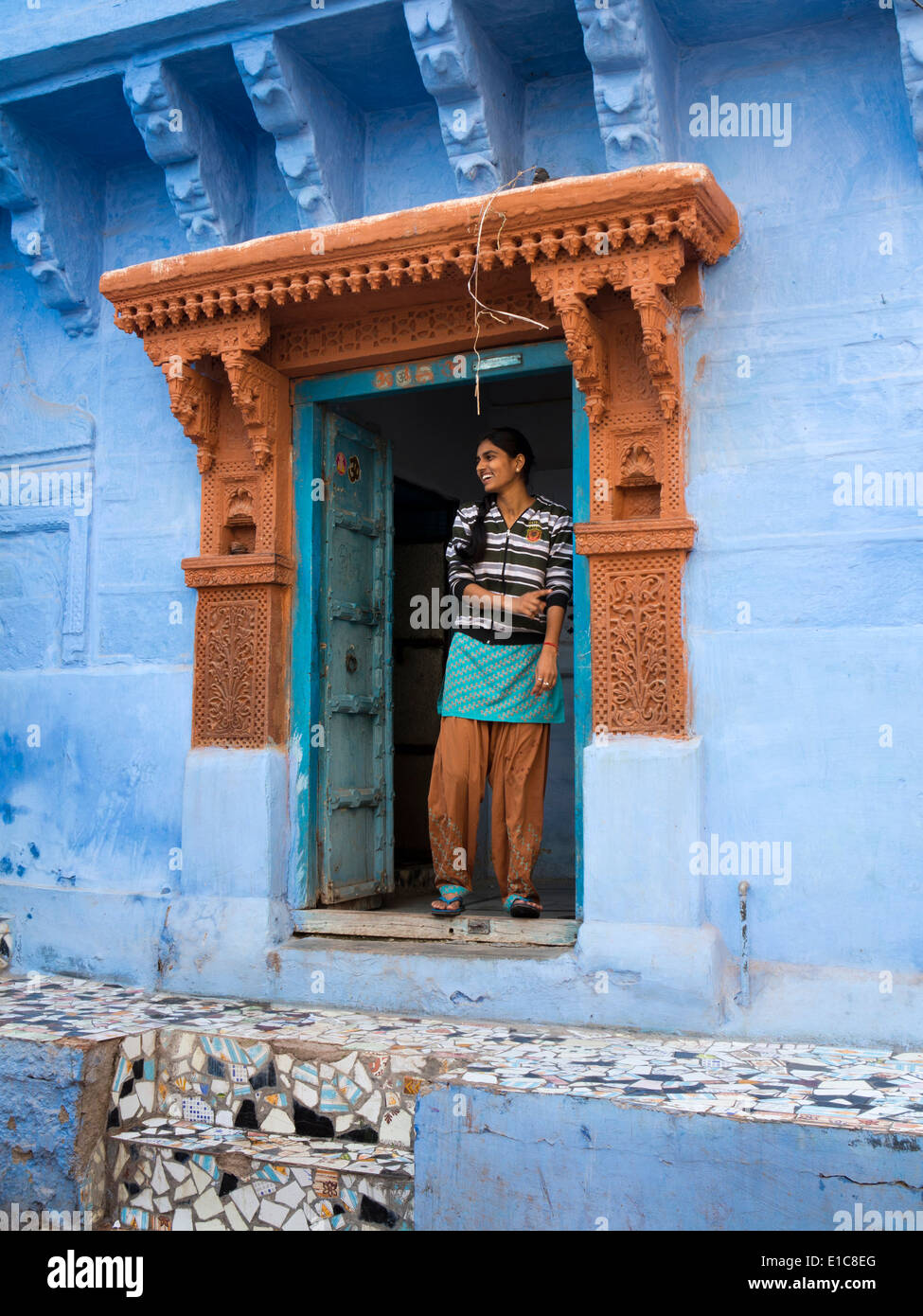 India Rajasthan, Jodhpur, giovane donna nella porta di blu dipinto di proprietà Foto Stock