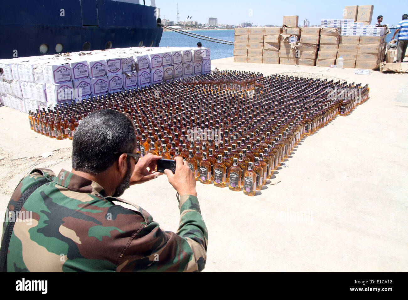 Tripoli. Il 30 maggio 2014. Una guardia costiera prende le immagini dell'alcool sequestrato il 30 maggio 2014, a Tripoli, in Libia. Libia la guardia costiera venerdì ha mostrato una partita di alcole sequestrati durante la loro sorveglianza off costa. Divieto di alcol è eseguita in uno stato islamico della Libia. © Hamza Turkia/Xinhua/Alamy Live News Foto Stock