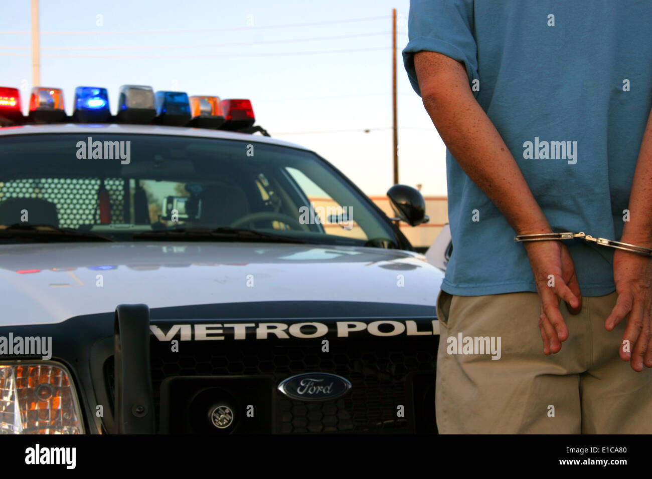 Ammanettato uomo in piedi di fronte a una macchina della polizia, Las Vegas, Nevada, STATI UNITI D'AMERICA Foto Stock Ammanettato uomo in piedi di fronte a una macchina della polizia, Las Vegas, Nevada, STATI UNITI D'AMERICA Foto Stock