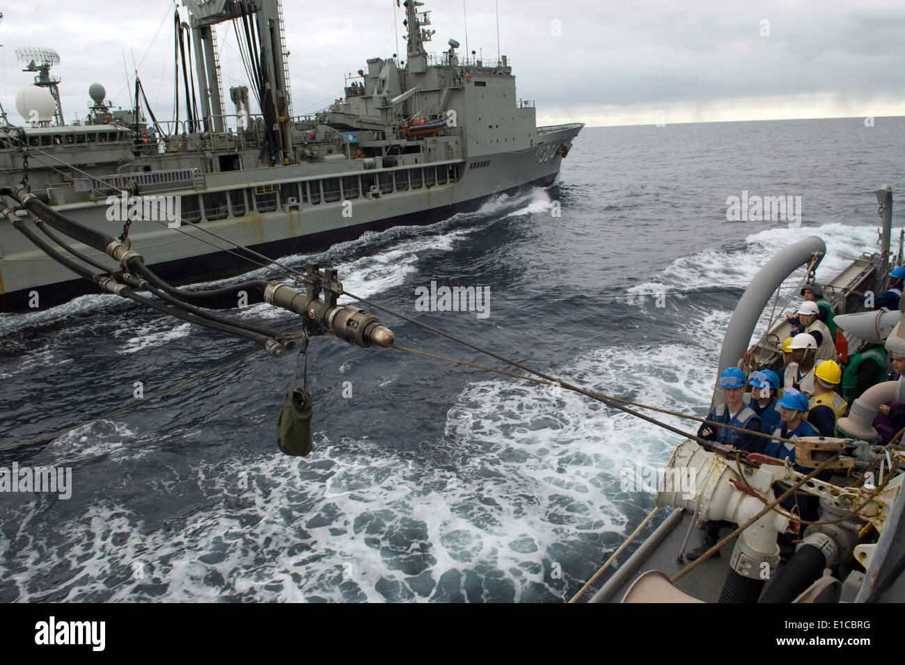 Sito ufficiale della Royal Navy i marinai a bordo del rifornimento HMAS oliatore successo (AOR 304) inviare una sonda del carburante per gli Stati Uniti Navy guidato-m Foto Stock