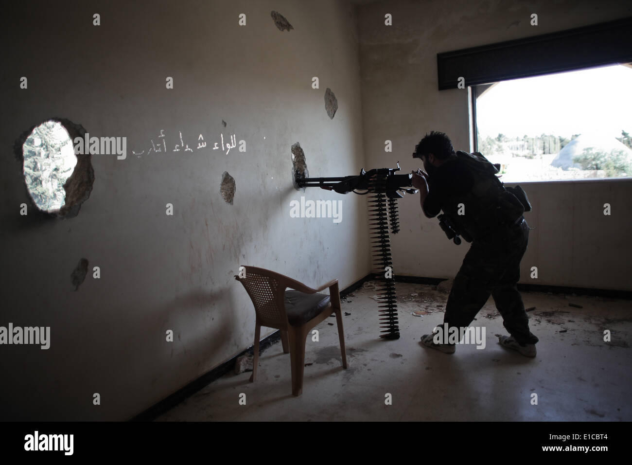 Aleppo, Siria. Il 30 maggio 2014. Un libero esercito siriano fighter incendi la sua arma pesante durante gli scontri con le forze fedeli alla Siria il Presidente Bashar al-Assad nel Khan al-Assal comune per il controllo della città nei pressi di Aleppo il 30 maggio 2013. Regime e le forze di opposizione sono in lotta per il controllo del Khan Al-Assal area come è il Gateway principale per Aleppo, che si trova a 12km (7 miglia) ad ovest della città, nonché per la sua grande inventario di carburante e olio. Credito: Ahmed Deeb/NurPhoto/ZUMAPRESS.com/Alamy Live News Foto Stock