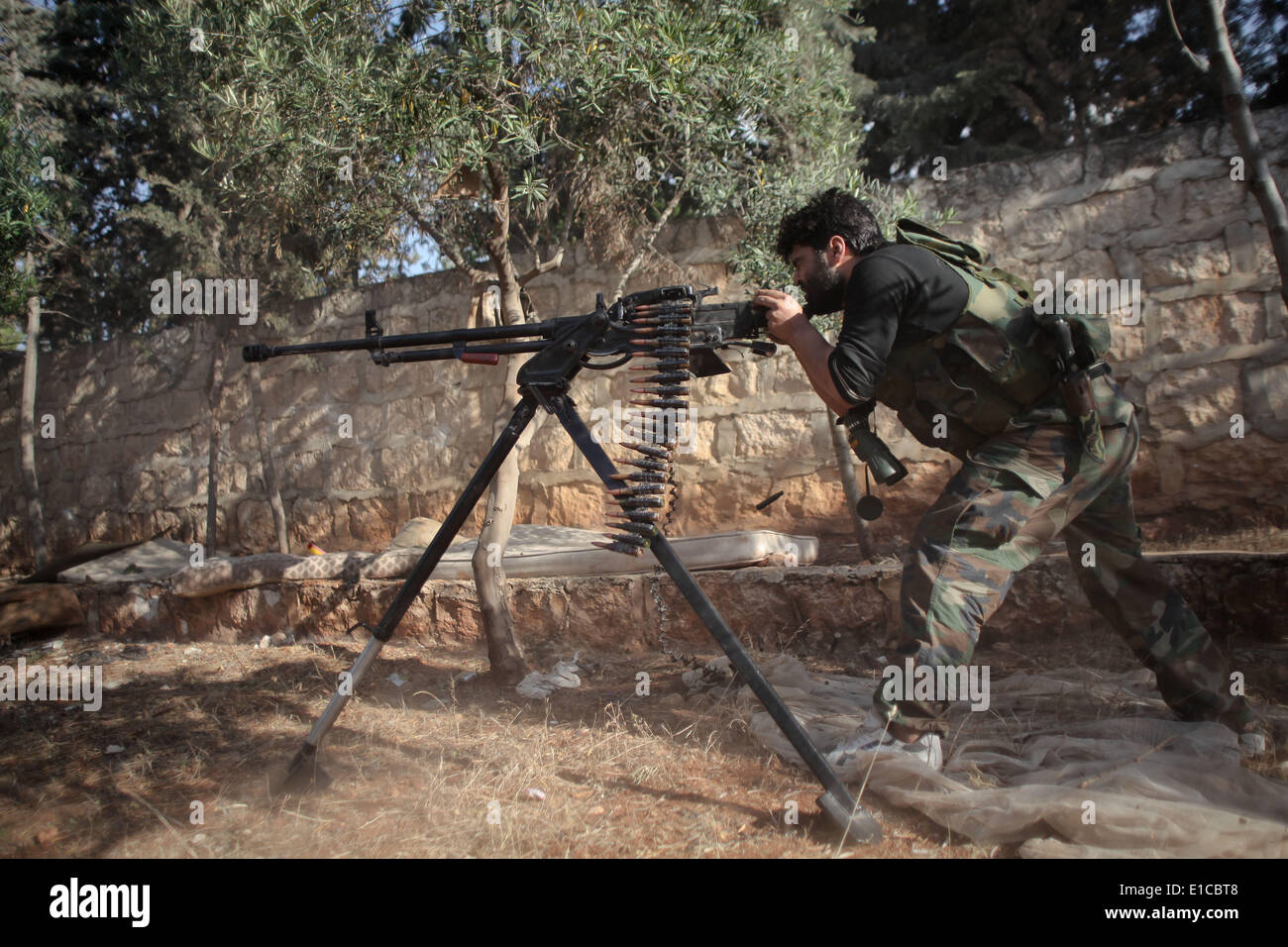 Aleppo, Siria. Il 30 maggio 2014. Un libero esercito siriano fighter incendi la sua arma pesante durante gli scontri con le forze fedeli alla Siria il Presidente Bashar al-Assad nel Khan al-Assal comune per il controllo della città nei pressi di Aleppo il 30 maggio 2013. Regime e le forze di opposizione sono in lotta per il controllo del Khan Al-Assal area come è il Gateway principale per Aleppo, che si trova a 12km (7 miglia) ad ovest della città, nonché per la sua grande inventario di carburante e olio. Credito: Ahmed Deeb/NurPhoto/ZUMAPRESS.com/Alamy Live News Foto Stock