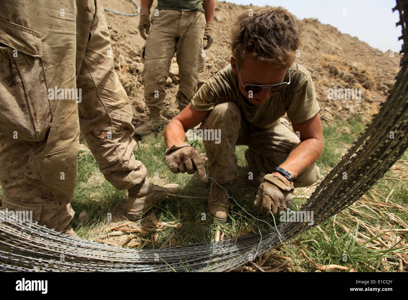 Stati Uniti Marine Corps Sgt. Beau Varner, un ingegnere consulente con società alfa, 1° Battaglione, quinto reggimento Marine, si snoda un bundle Foto Stock