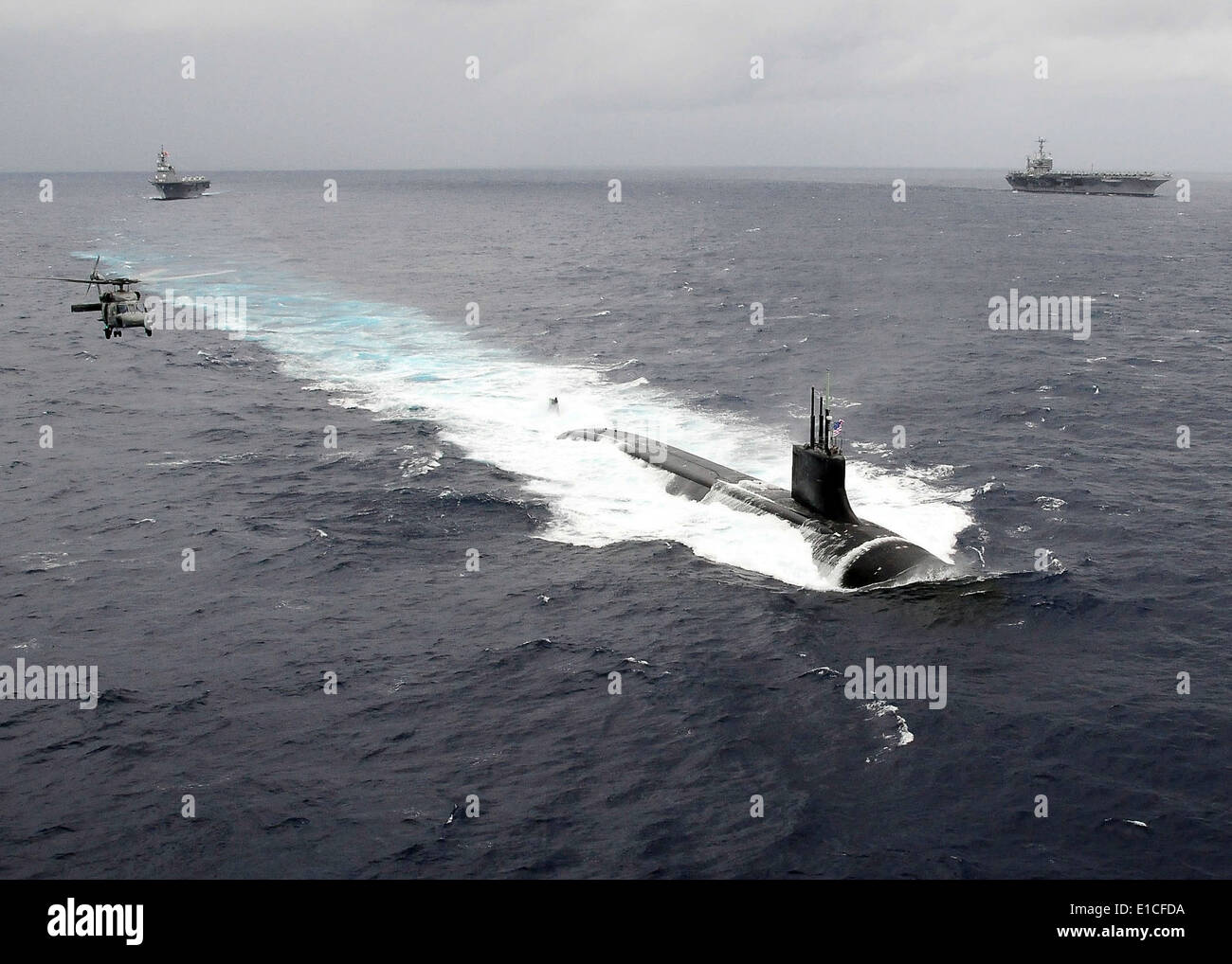 Il gatto artico-class attack submarine USS Connecticut (SSN 22) transita l'Oceano Pacifico nov. 17, 2009, come un HH-60H Seahawk heli Foto Stock