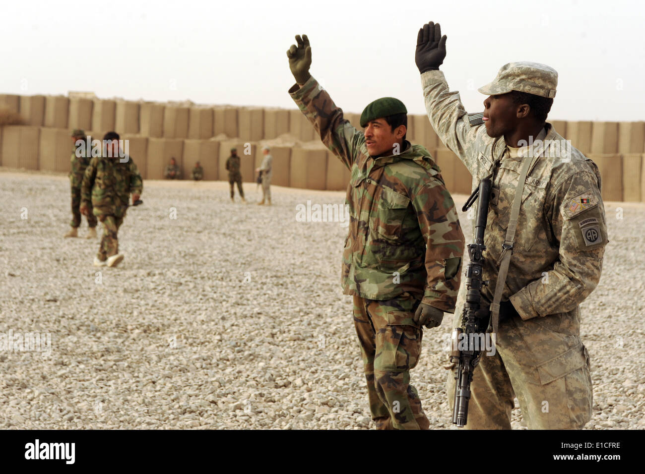Stati Uniti Army Spc. Taji Purdie, 2° Battaglione, 321 campo reggimento di artiglieria e un soldato afgano pratica segnali del braccio durante un jo Foto Stock