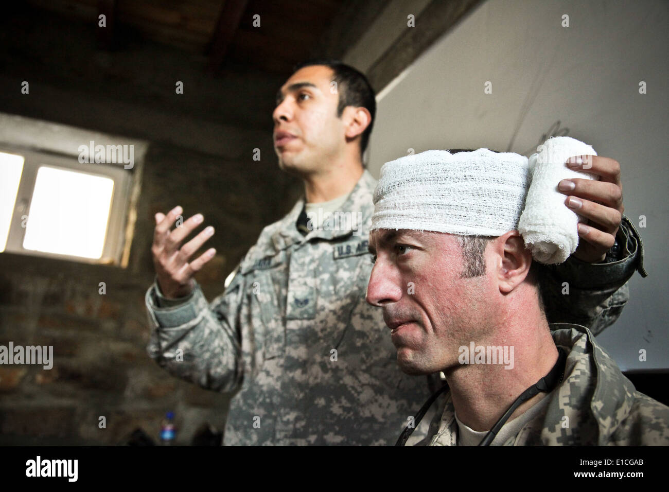 Stati Uniti Air Force Capt. John Stamm simula una persona con una lesione alla testa mentre il personale Sgt. Abramo Jara spiega la procedu corretta Foto Stock