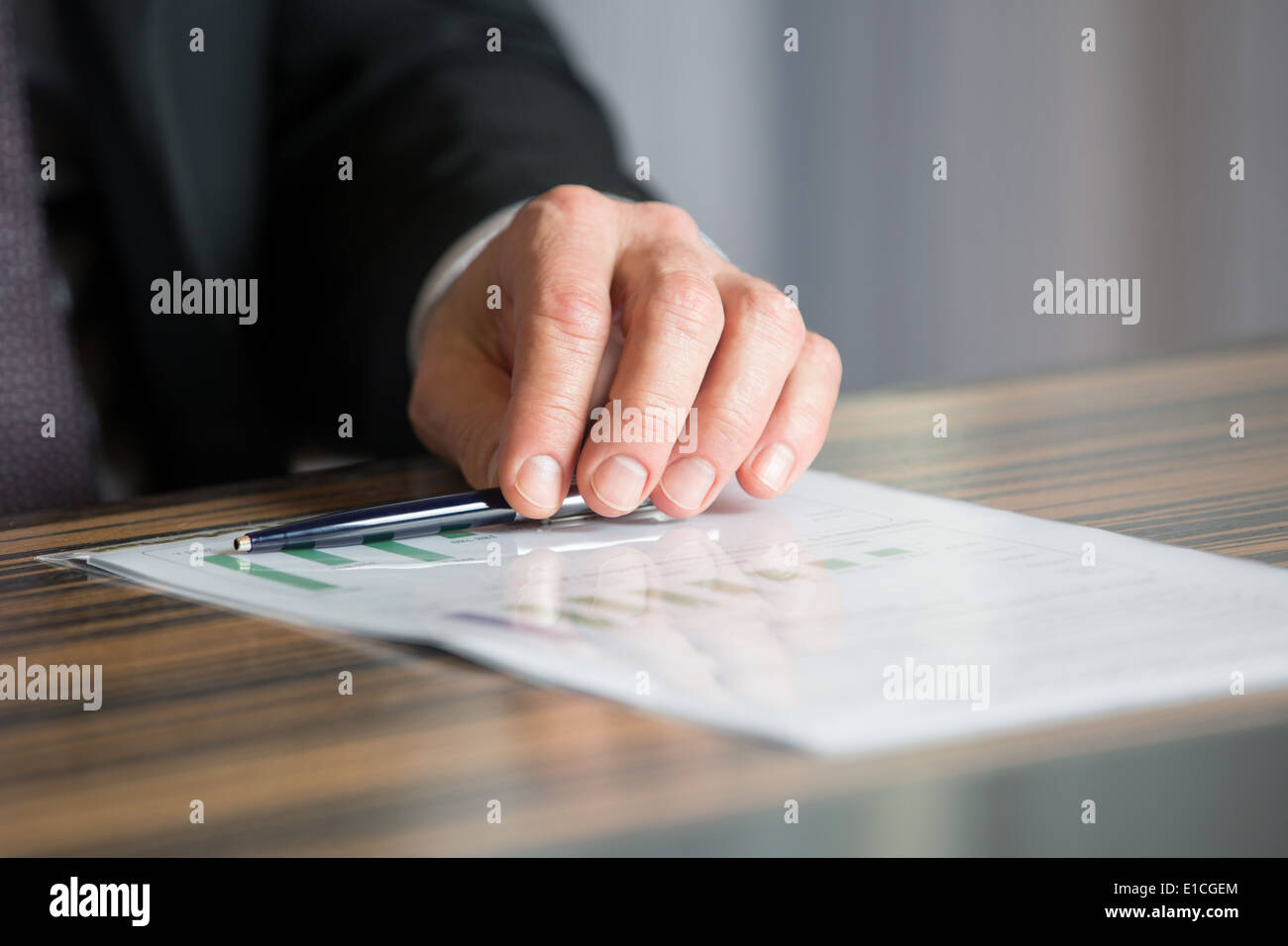 Uomo con le mani in mano in possesso di una penna nera in entrambe le braccia in un gesto di pensiero durante una riunione o negoziazione Foto Stock