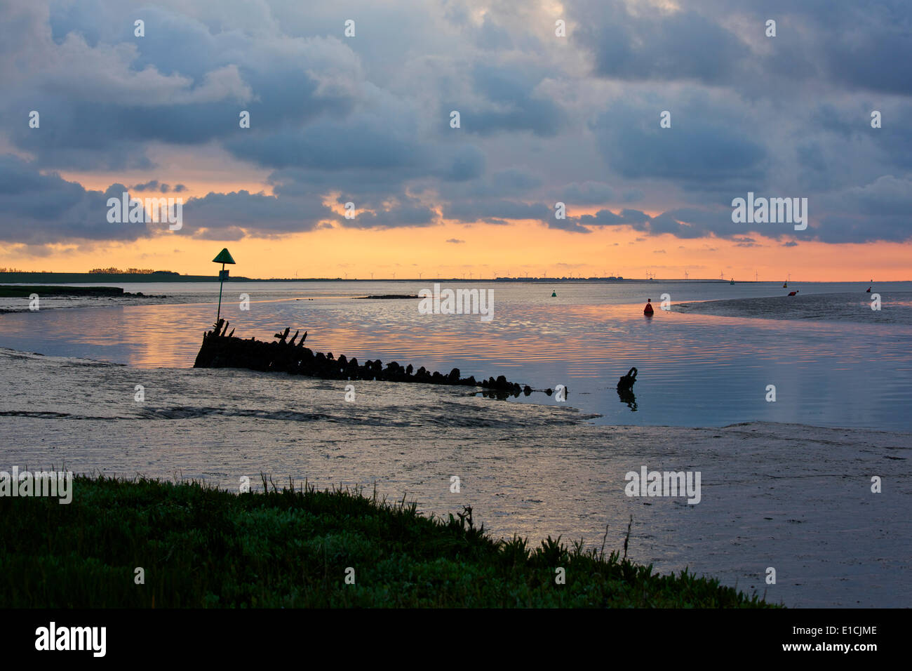 Swale estuario vicino a Faversham Kent REGNO UNITO 31 Maggio 2014: Il sole sorge su un antico relitto come la marea si spegne. La Kentish Flats wind farm può essere visto all'orizzonte oltre l'Isle of Sheppey. Come le previsioni di una delle molle più caldi sul record continua, un bel giorno inizia il weekend come le docce di precedenti giorni Chiara lontano, benché le prospettive per la prossima settimana è una miscela di docce e le magie di sole Foto Stock