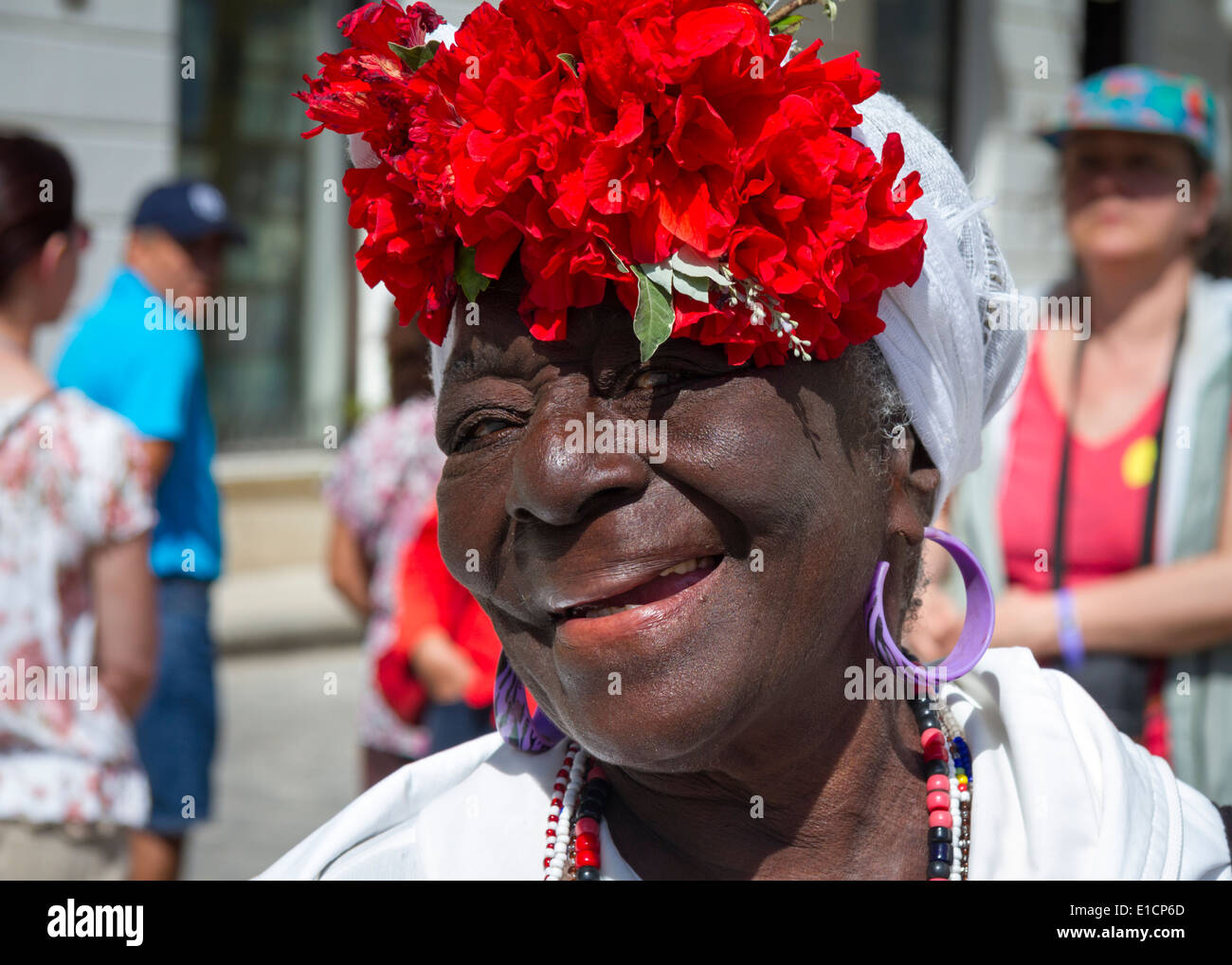 Ritratto di viaggio, felice donna cubana locale posa con cappello rosso fiore, sorridente, la Habana Vieja, l'Avana Vecchia, Cuba Foto Stock