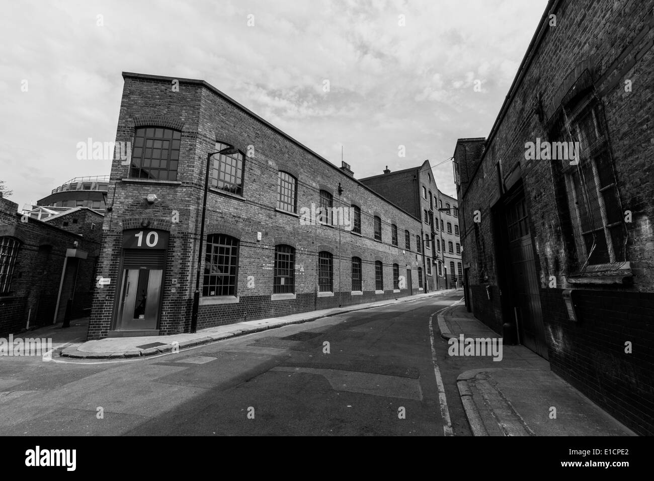 Tipico London Street nella zona est di Londra che mostra di vecchi magazzini e dock Foto Stock