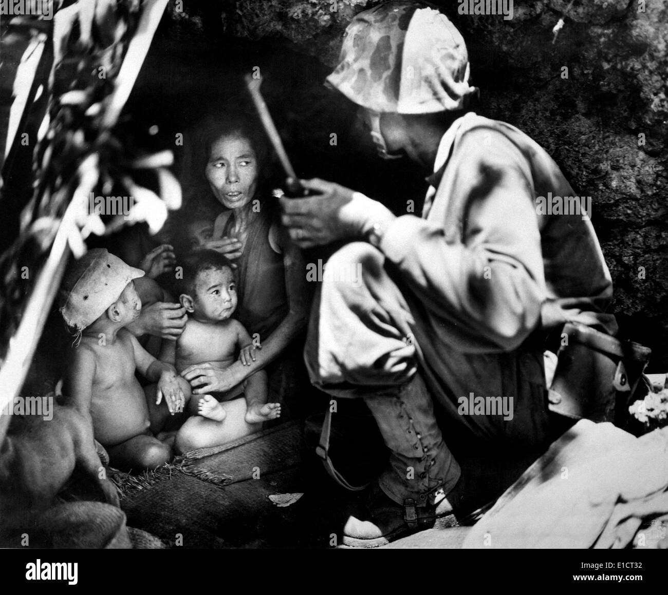 Pattuglia Marina su Saipan trovato una famiglia giapponese il ricovero in una grotta in collina, giugno 21,1944. 1.000 dei 25.000 civili su Foto Stock