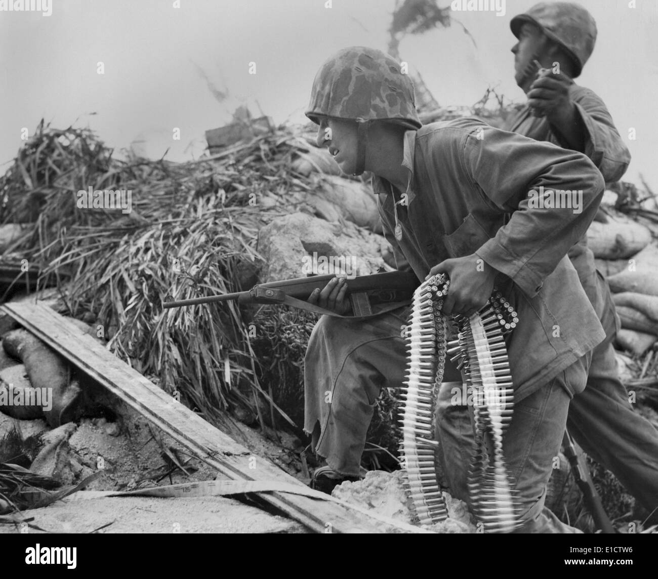 A Tarawa, U.S. Marine, con una carabina e una dei nastri di proiettili. Egli attende il suo amico a lanciare una bomba a mano, prima che egli Foto Stock